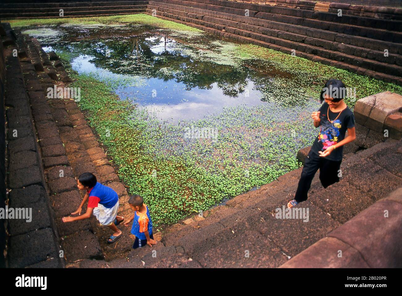Thaïlande : les enfants jouent autour de l'un des chars du temple, Prasat Mueang Tam, province de Buriram, nord-est de la Thaïlande. Prasat Hin Mueang Tam est un temple khmer dans les styles Khleang et Baphuon, qui date de la fin du Xe siècle et du début du XIe siècle. La divinité primaire était Shiva, bien que Vishnu était également adoré ici. Prasat Mueang Tam a été construit sur les ordres du roi Jayavarman V. entouré d'un haut mur de latérite, le complexe comprend de magnifiques réservoirs étagés qui ont été restaurés avec amour et remplis de fleurs de lotus. Banque D'Images Thaïlande : les enfants jouent autour de l'un des chars du temple, Prasat Mueang Tam, province de Buriram, nord-est de la Thaïlande. Prasat Hin Mueang Tam est un temple khmer dans les styles Khleang et Baphuon, qui date de la fin du Xe siècle et du début du XIe siècle. La divinité primaire était Shiva, bien que Vishnu était également adoré ici. Prasat Mueang Tam a été construit sur les ordres du roi Jayavarman V. entouré d'un haut mur de latérite, le complexe comprend de magnifiques réservoirs étagés qui ont été restaurés avec amour et remplis de fleurs de lotus. Banque D'Images