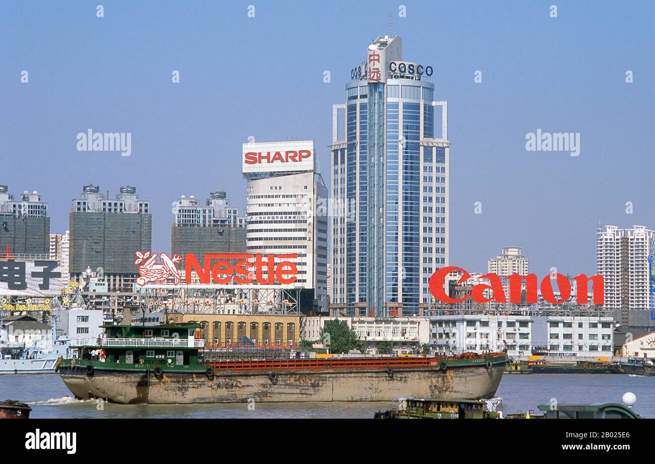 Chine : trafic commercial sur le fleuve Huangpu, Shanghai, 2000. Shanghai a commencé sa vie comme un village de pêcheurs, et plus tard comme un port recevant des marchandises transportées sur le fleuve Yangzi. À partir de 1842, au lendemain de la première guerre de l’opium, les Britanniques ont ouvert une « concession » à Shanghai où les trafiquants de drogue et autres commerçants pouvaient opérer sans être dérangés. Les Français, les Italiens, les Allemands, les Américains et les Japonais ont tous suivi. Dans les années 1920 et 1930, Shanghai était une ville florissante et un synonyme international de dissipation. Lorsque les communistes ont gagné le pouvoir en 1949, ils ont transformé Shanghai en un modèle de la Révolution. Banque D'Images