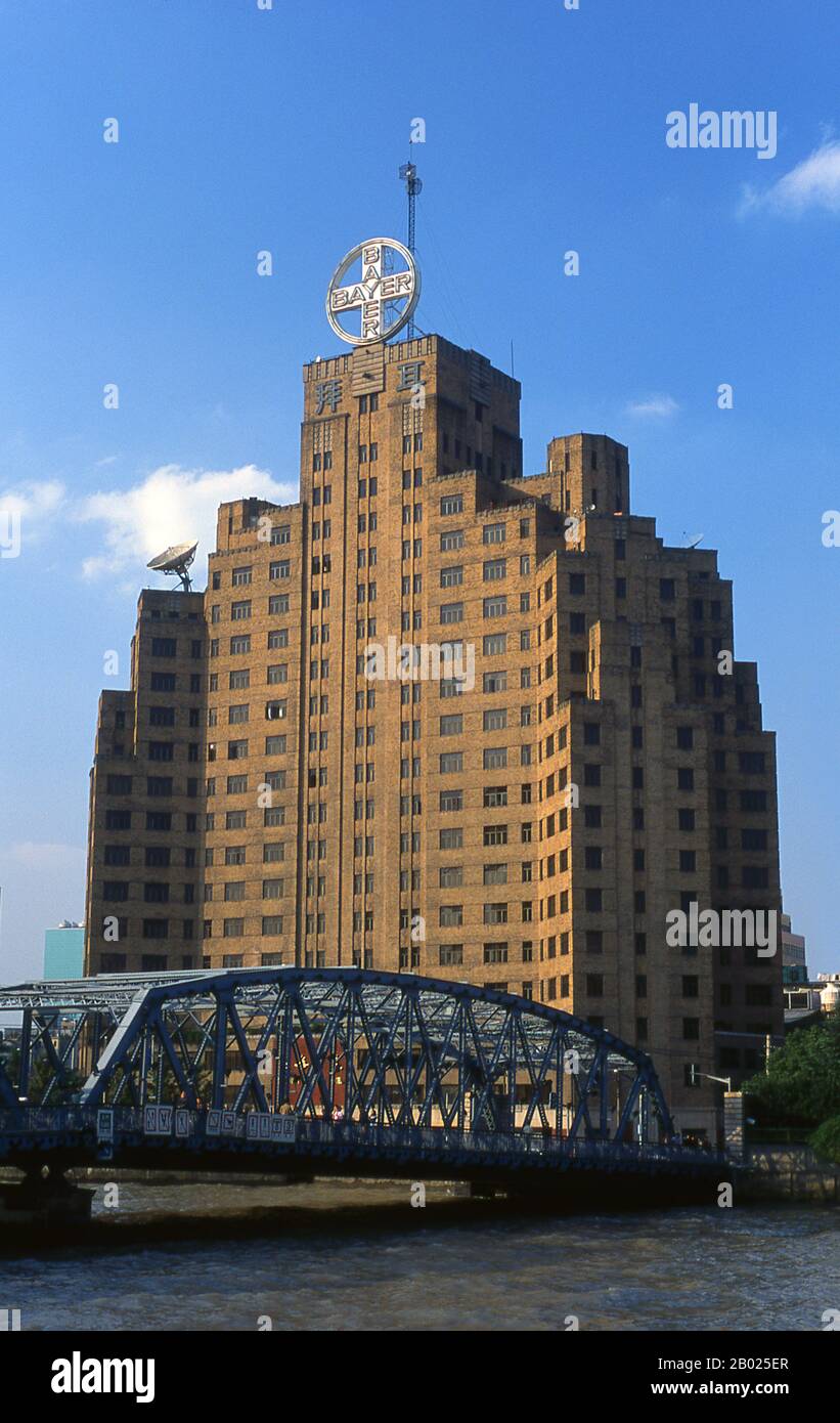 Chine : bâtiment Bayer et pont Waibaidu à Suzhou Creek, Shanghai, 2000. Shanghai a commencé sa vie comme un village de pêcheurs, et plus tard comme un port recevant des marchandises transportées sur le fleuve Yangzi. À partir de 1842, au lendemain de la première guerre de l’opium, les Britanniques ont ouvert une « concession » à Shanghai où les trafiquants de drogue et autres commerçants pouvaient opérer sans être dérangés. Les Français, les Italiens, les Allemands, les Américains et les Japonais ont tous suivi. Dans les années 1920 et 1930, Shanghai était une ville florissante et un synonyme international de dissipation. Banque D'Images