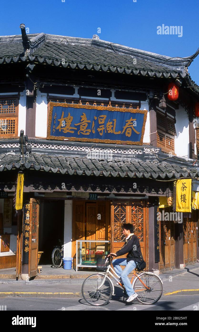 Chine : un cycliste devant une maison de thé sur Fangbang lu à Nanshi ou dans la vieille ville de Shanghai. Shanghai a commencé sa vie comme un village de pêcheurs, et plus tard comme un port recevant des marchandises transportées sur le fleuve Yangzi. À partir de 1842, au lendemain de la première guerre de l’opium, les Britanniques ont ouvert une « concession » à Shanghai où les trafiquants de drogue et autres commerçants pouvaient opérer sans être dérangés. Les Français, les Italiens, les Allemands, les Américains et les Japonais ont tous suivi. Dans les années 1920 et 1930, Shanghai était une ville florissante et un synonyme international de dissipation. Banque D'Images