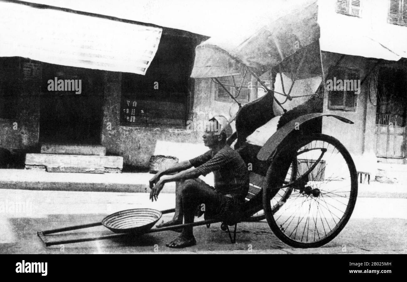 Vietnam : chauffeur de pousse-pousse, Hoi an, v. 1930. La petite ville historique de Hoi an est située sur la rivière Thu bon à 30 km (18 miles) au sud de Danang. À l'époque des seigneurs Nguyen (1558-1777) et même sous les premiers empereurs Nguyen, Hoi an - alors connu sous le nom de Faifo - était un port important, visité régulièrement par les navires d'Europe et de tout l'est. À la fin du XIXe siècle, l'envasement de la rivière Thu bon et le développement de Danang à proximité avaient fait de Hoi an un remous. Cette obscurité a sauvé la ville des combats sérieux pendant les guerres avec la France et les États-Unis. Banque D'Images