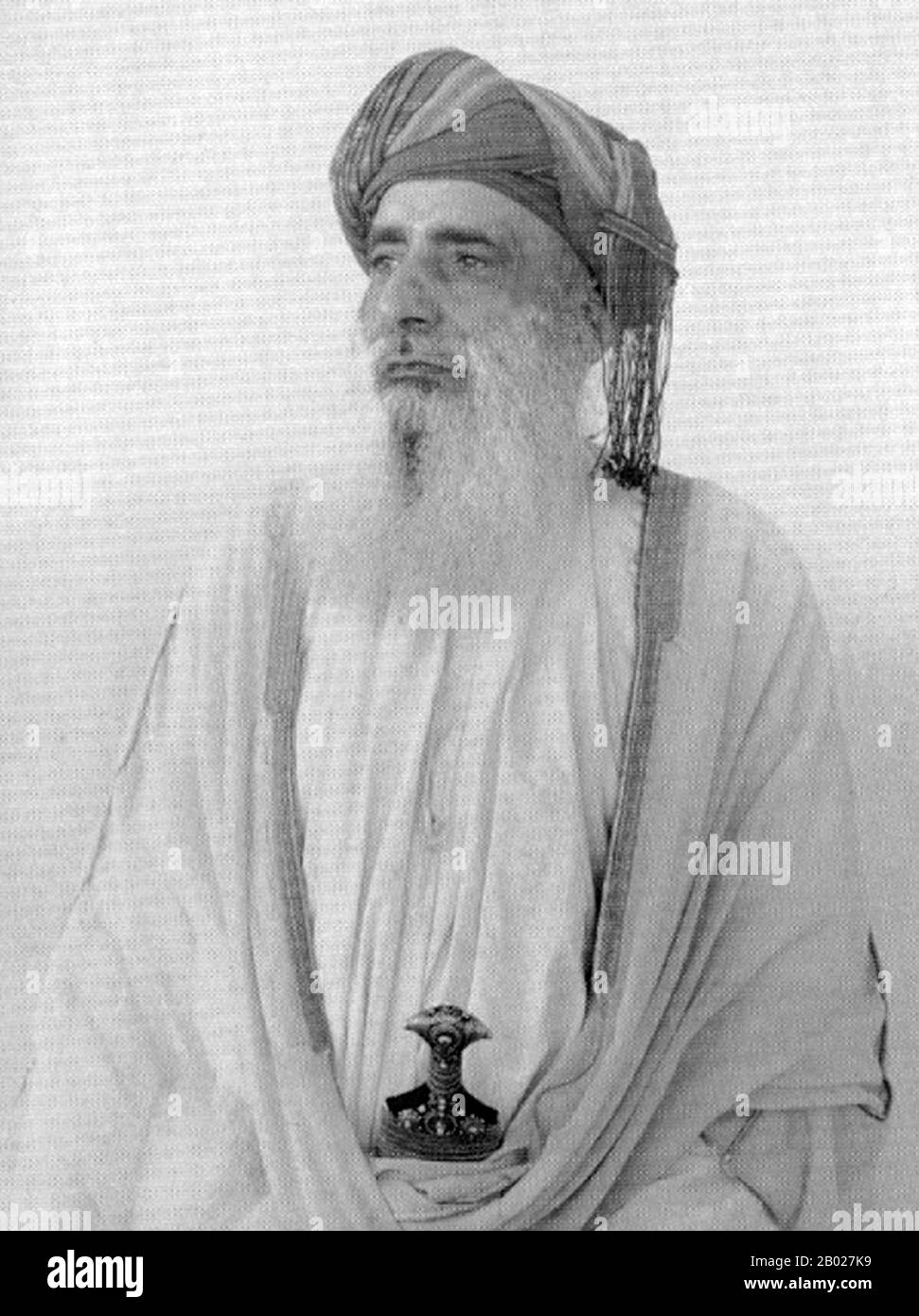 Oman : Ahmed bin Ibrahim al-Busaidi, ministre de l'intérieur sous le sultan Sayyid bin Taimur (R. 1932-1970), milieu du XXe siècle. Oman, officiellement appelé Sultanat d'Oman, est un État arabe du sud-ouest de l'Asie sur la côte sud-est de la péninsule arabique. Il occupe une position stratégique importante à l'embouchure du golfe Persique. Il est bordé par les Émirats arabes Unis (eau) au nord-ouest, l'Arabie saoudite à l'ouest et le Yémen au sud-ouest et partage également une frontière maritime avec l'Iran. La côte est formée par la mer d'Arabie au sud-est et le golfe d'Oman au nord-est. Banque D'Images