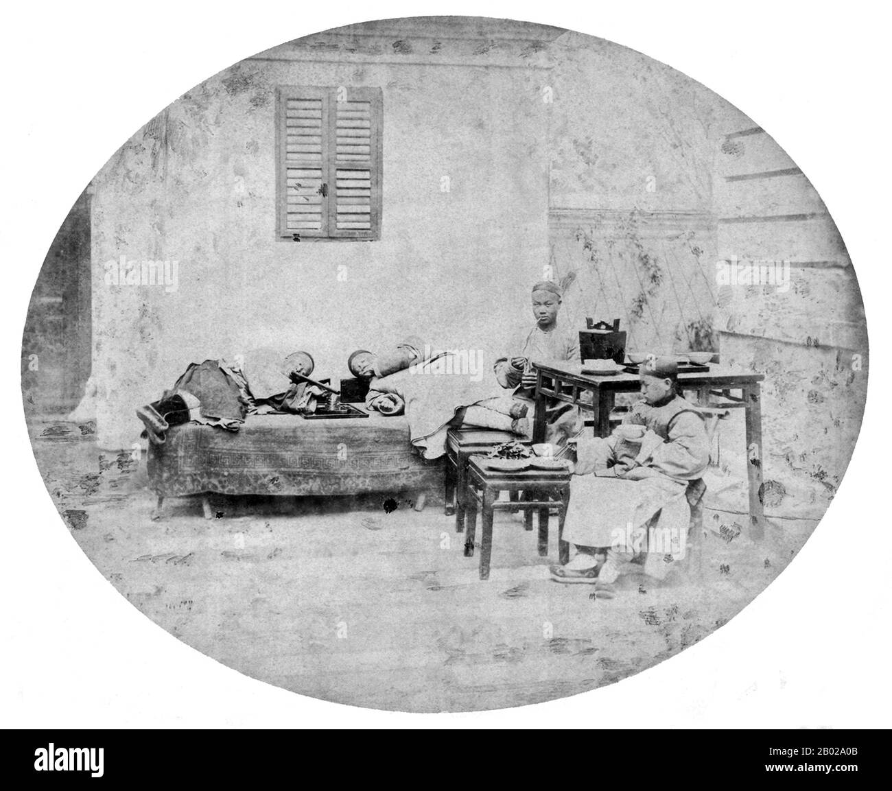 Chine : fumeurs d'opium, Shanghai. Photo d'Adolf-Nikolay Erazmovitch Boiarskii (fl. 1874), 1874. Le pavot à opium, Papaver somniferum, est l'espèce de plante dont sont extraits l'opium et les graines de pavot. L'opium est la source de nombreux opiacés, dont la morphine, la thébaïne, la codéine, la papavérine et la noscapine. Le nom botanique latin signifie le « pavot qui apporte le sommeil », se référant aux propriétés sédatives de certains de ces opiacés. Banque D'Images