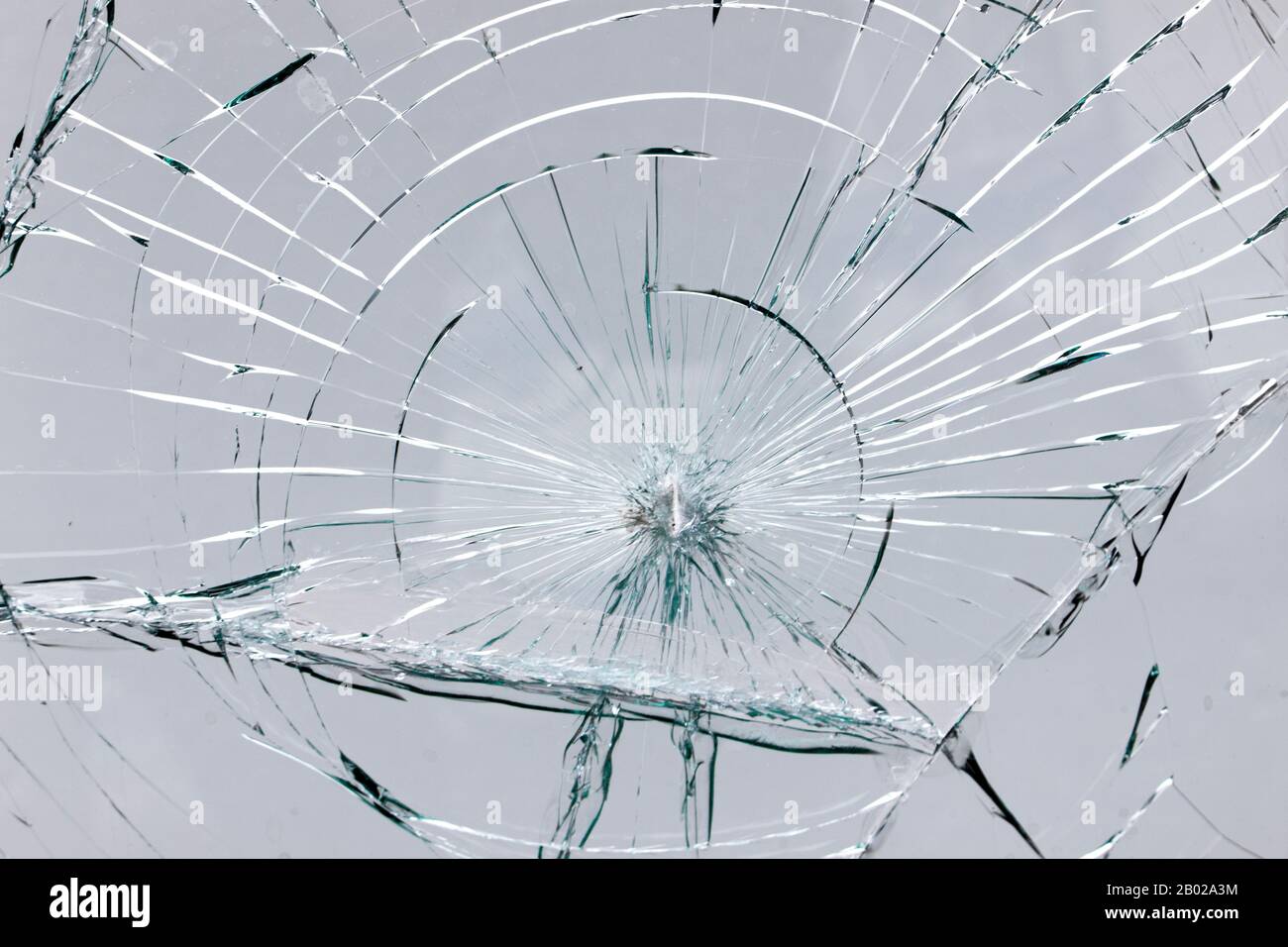 Fissures sur le verre cassé à l'impact, fontaine blanche de ligne de fissure sur la fenêtre. Banque D'Images