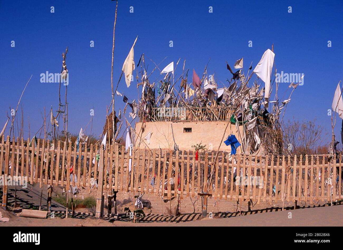 Chine : un tombeau dans les dunes de sable près de l'Imam Asim Mazar (sanctuaire) dans le désert près de Khotan, province du Xinjiang. Le sanctuaire de l'Imam Asim et d'autres tombes se trouvent à 23 kilomètres de Khotan (Hotan) sur la route de la soie au sud. C'est le site d'un immense pèlerinage chaque mois de mai. L’Imam Asim a été l’un des premiers missionnaires islamiques à visiter cette région. Khotan retrace son histoire au moins aussi loin que le IIIe siècle av. J.-C., lorsque le fils aîné de l'empereur indien Asoka s'est installé ici. C'était d'une grande importance sur la route de la soie. Banque D'Images