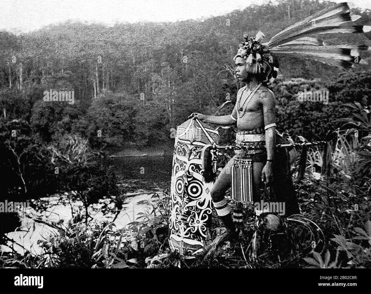 Malaisie : un Dayak de mer (IBAN) de Sarawak en habillement de guerrier complet, début du XXe siècle. Les Dayak ou Dyak sont des autochtones de Bornéo. « Dayak » est un terme vague désignant plus de 200 sous-groupes ethniques riverains et montagneux, situés principalement à l'intérieur de Bornéo, chacun ayant son propre dialecte, ses coutumes, ses lois, son territoire et sa culture, bien que les traits distinctifs communs soient facilement identifiables. Les langues Dayak sont classées dans la catégorie des langues austronésiennes en Asie. Les Dayak étaient animistes dans la croyance ; cependant beaucoup se sont convertis au christianisme, et certains ont embrassé l'islam plus récemment. Banque D'Images