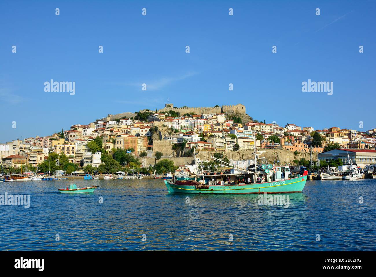 Kavala, Grèce - 17 septembre 2015 : personnes non identifiées sur un bateau de pêche dans le port de la ville d'Eastmacedonia, forteresse et différents bâtiments Banque D'Images