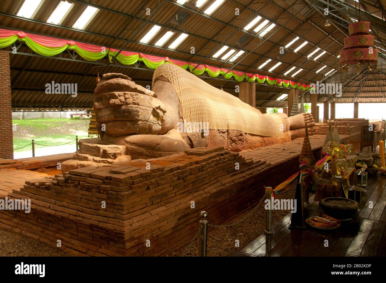 Le Bouddha incliné en grès logé au Wat Dharmacakra Semaram est le plus ancien Bouddha incliné de Thaïlande et remonte au VIIIe siècle ce. L'image de style Dvaravati est de 13,5 mètres de long Banque D'Images Le Bouddha incliné en grès logé au Wat Dharmacakra Semaram est le plus ancien Bouddha incliné de Thaïlande et remonte au VIIIe siècle ce. L'image de style Dvaravati est de 13,5 mètres de long Banque D'Images
