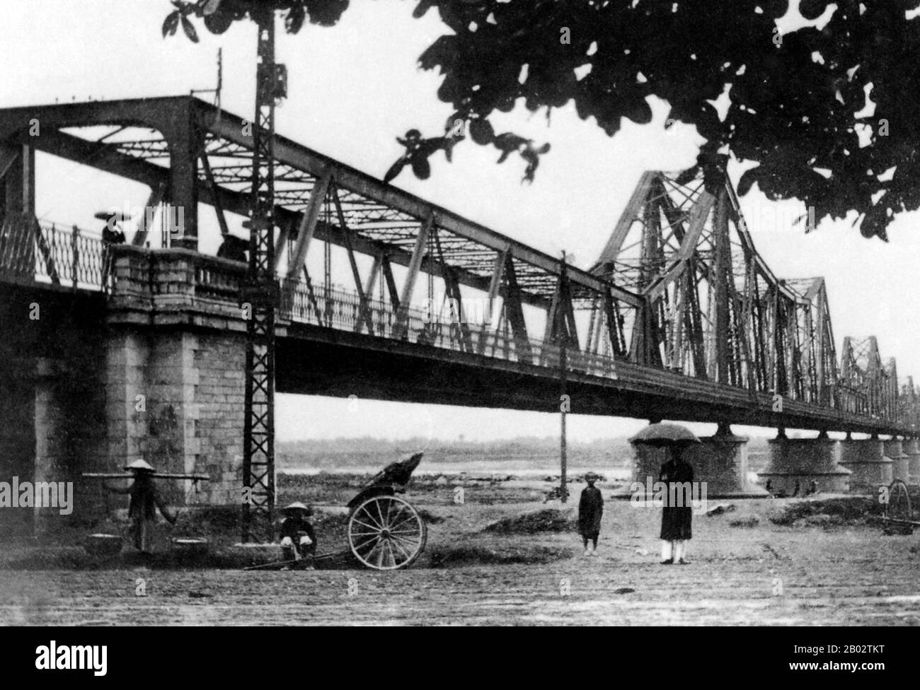 Le pont long-bien a été érigé par les colonialistes français entre 1899 et 1902 et nommé le pont Paul Doumer en l'honneur du gouverneur de l'Indochine française de l'époque (1897-1902). Il a été conçu et construit par Dayde et Pille de Paris (les plaques d'origine sont toujours en place) et mesure 1,682 mètres (5,518 pi) de long, comprenant 18 travées, avec une portée centrale supplémentaire allongée de 106 mètres (347 pi). Il porte la seule ligne ferroviaire entre Hanoi et Haiphong, ainsi que deux liaisons ferroviaires vitales avec la Chine; jusqu'à la construction du nouveau pont Chuong Duong en 1985, il portait également la seule route t Banque D'Images