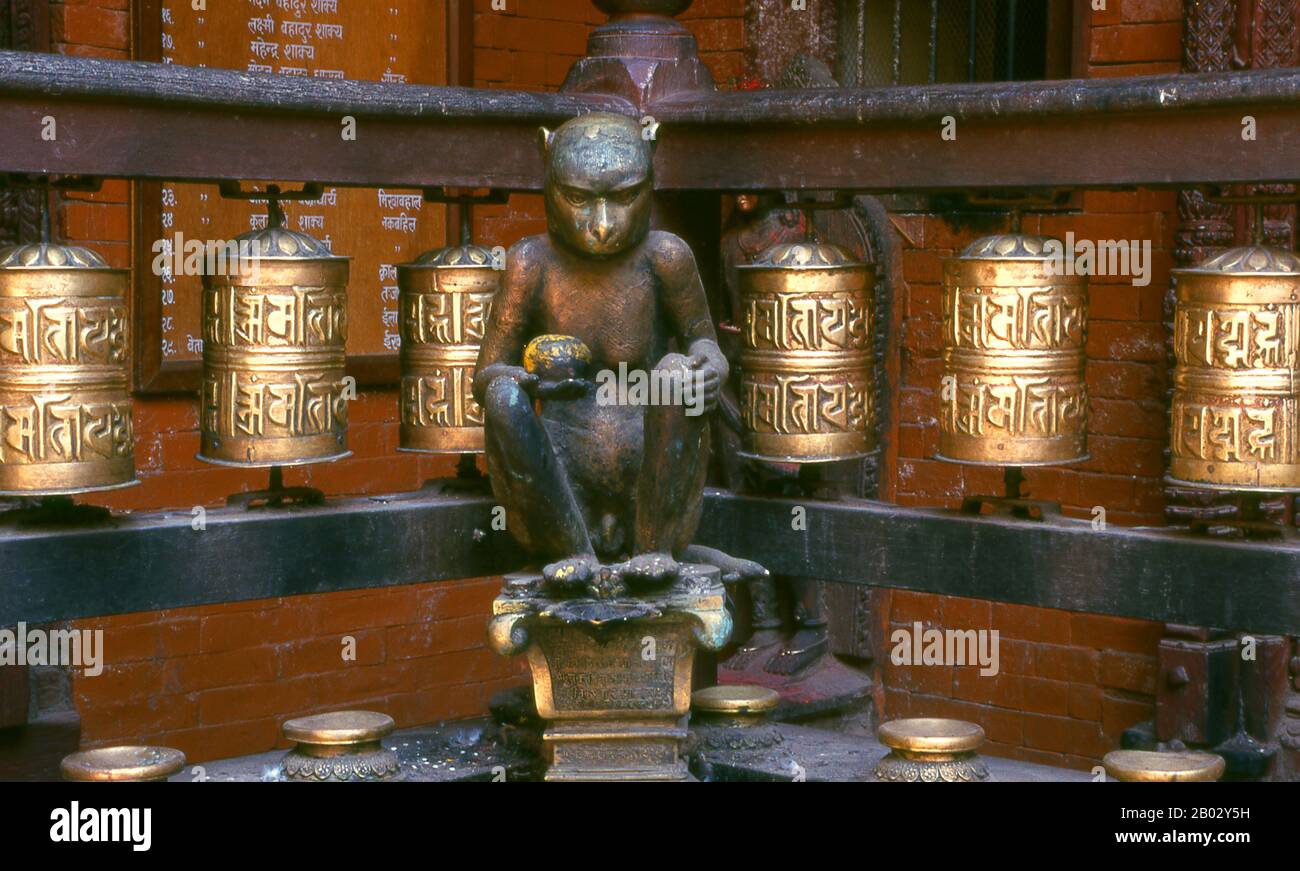 Népal: Une statue de bronze du dieu hindou Hanuman se trouve dans un coin au milieu des roues de prière bouddhiste à l'intérieur du Temple d'Or (Hiranyavarna Mahavihara), Patan, Vallée de Katmandou (1998). Le Hiranyavarna Mahavihara, ou Temple d'Or, est l'un des plus grands spectacles d'art et d'architecture de la vallée de Katmandou. Soi-disant fondé au 12th siècle par le roi Bhaskara Deva Varma, le temple, tel qu'il se présente aujourd'hui, remonte pour la plupart au 18th siècle. Toute la façade du sanctuaire principal est recouverte de cuivre doré, tout comme la torana très détaillée et tous les toits. Banque D'Images