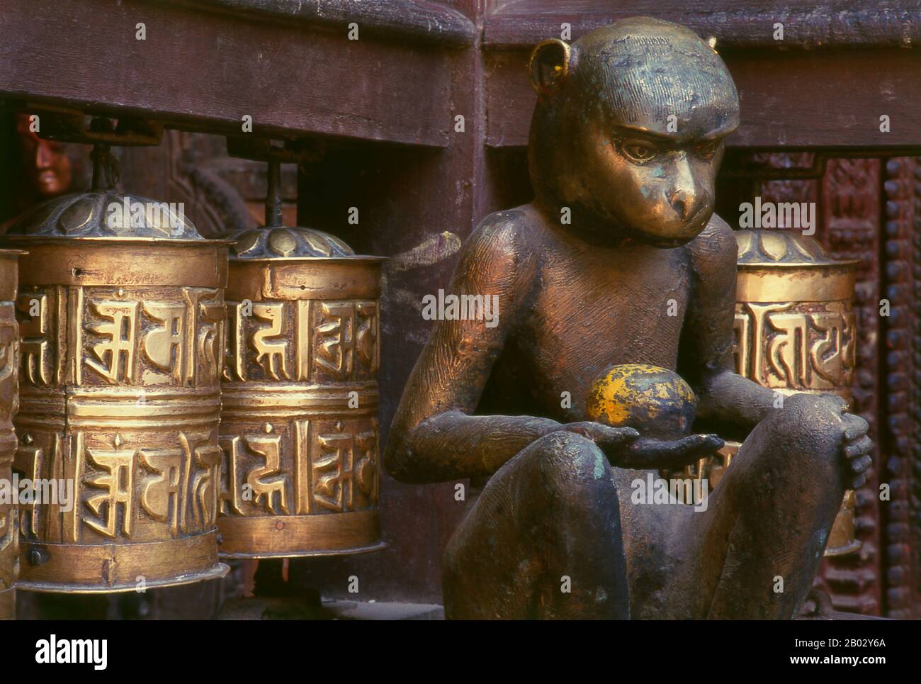 Népal: Une statue de bronze du dieu hindou Hanuman se trouve dans un coin au milieu des roues de prière bouddhiste à l'intérieur du Temple d'Or (Hiranyavarna Mahavihara), Patan, Vallée de Katmandou (1998). Le Hiranyavarna Mahavihara, ou Temple d'Or, est l'un des plus grands spectacles d'art et d'architecture de la vallée de Katmandou. Soi-disant fondé au 12th siècle par le roi Bhaskara Deva Varma, le temple, tel qu'il se présente aujourd'hui, remonte pour la plupart au 18th siècle. Toute la façade du sanctuaire principal est recouverte de cuivre doré, tout comme la torana très détaillée et tous les toits. Banque D'Images
