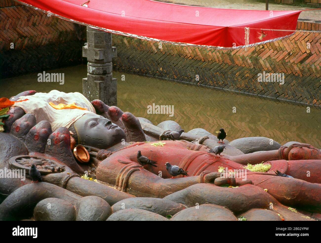 La figure de Vishnu de Budhanilkantha est une figure de 4,5 mètres de long, finement sculptée représentant Vishnu dormant sur le sol de l'océan cosmique, sur un "lit" de corps de serpent entrelaçant, qui font tous partie du serpent géant à onze têtes Ananta, "L'Infini". La figure est probablement née au VIIe siècle et est à l'origine d'un seul morceau de roche. Selon la légende, Budhanilkantha a été découvert par un agriculteur tout en lavant son champ; la charrue s'est enlancée sur le chiffre, qui a été enterré sous terre, et, à la grande surprise de l'agriculteur, le chiffre a commencé à saigner. Budha signifie « mud » et ni Banque D'Images