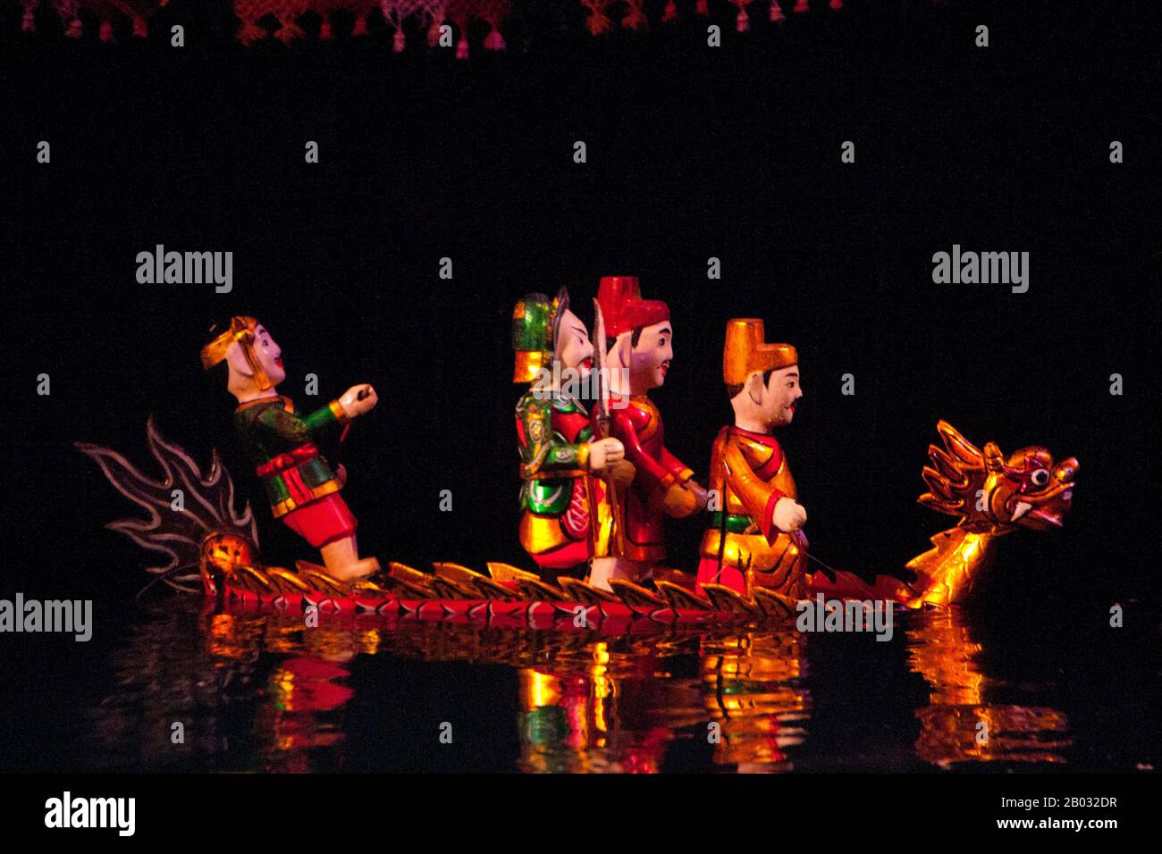 Water Puppetry ou Múa rối nước, littéralement "marionnettes qui dansent sur l'eau" est originaire du Delta de la rivière Rouge. Les marionnettes sont sculptées de bois résistant à l'eau pour représenter les styles de vie ruraux traditionnels et les créatures mythiques. Debout derrière la scène aquatique, au fond de la taille dans l'eau, les marionnettes cachées manœuvrent habilement leurs charges en bois à la musique d'un orchestre traditionnel. Banque D'Images