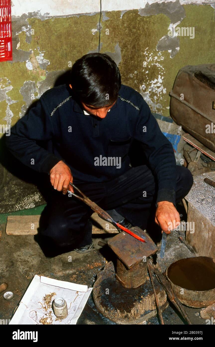 La petite oasis dominée par les ouïghours de Yengisar (Yingjisha) est connue dans toute la province chinoise occidentale du Xinjiang pour sa production de couteaux faits à la main. La petite usine de couteaux (Pichak Chilik Karakhana / Xiaochang) emploie des artisans locaux qualifiés produisant des couteaux fins avec des poignées incrustées. Juste à peu près chaque homme d'Ouïghour porte un couteau, à la fois comme signe de la manhood et pour le but plus utilitaire de couper des melons, et les plus valorisés (et coûteux) viennent de Yengisar. Banque D'Images