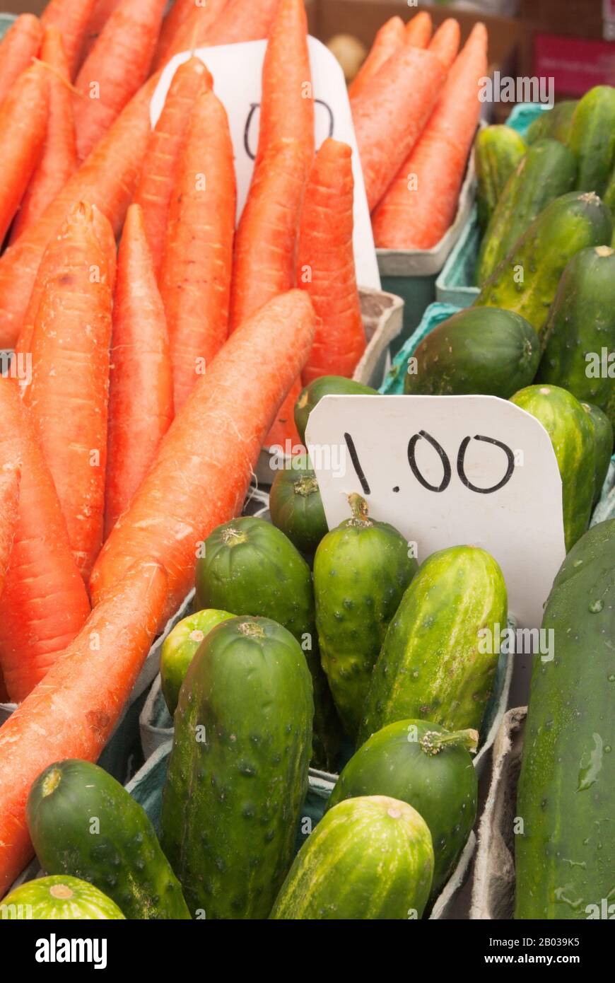 Carottes et concombres crus à vendre sur un marché agricole extérieur à Baltimore MD USA. Banque D'Images