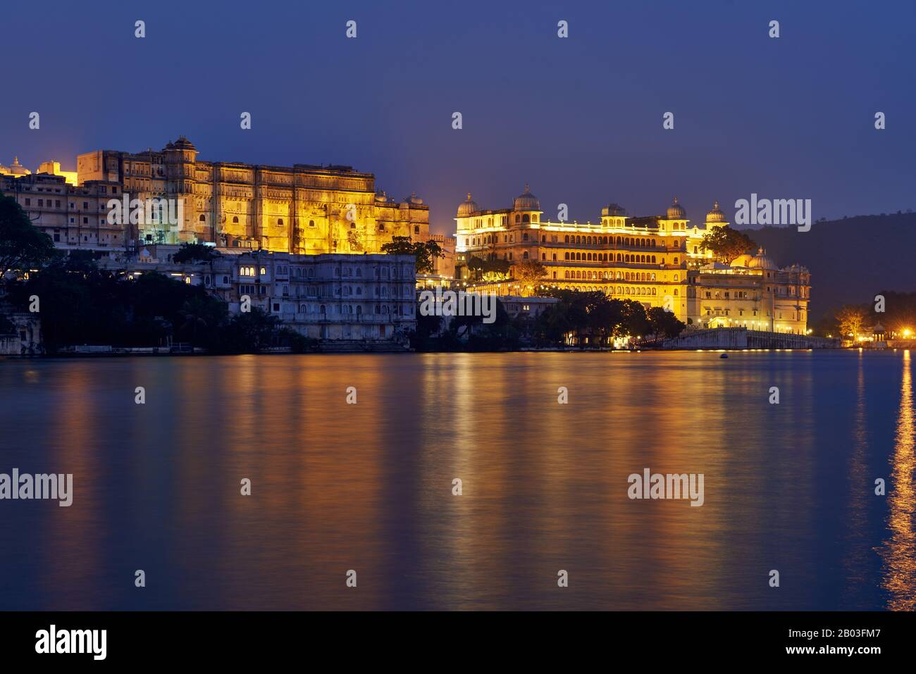 La nuit a tourné au-dessus du lac Pichola sur le palais illuminé de la ville et le palais Taj Fateh Prakash d'Udaipur, Rajasthan, Inde Banque D'Images
