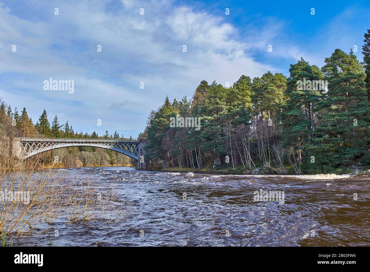 VILLAGE DE CARRON MORAY ECOSSE VUE DE RIVER BANK À LA ROUTE UNIQUE DE CARRON ET ANCIEN PONT FERROVIAIRE QUI TRAVERSE LA RIVIÈRE SPEY Banque D'Images