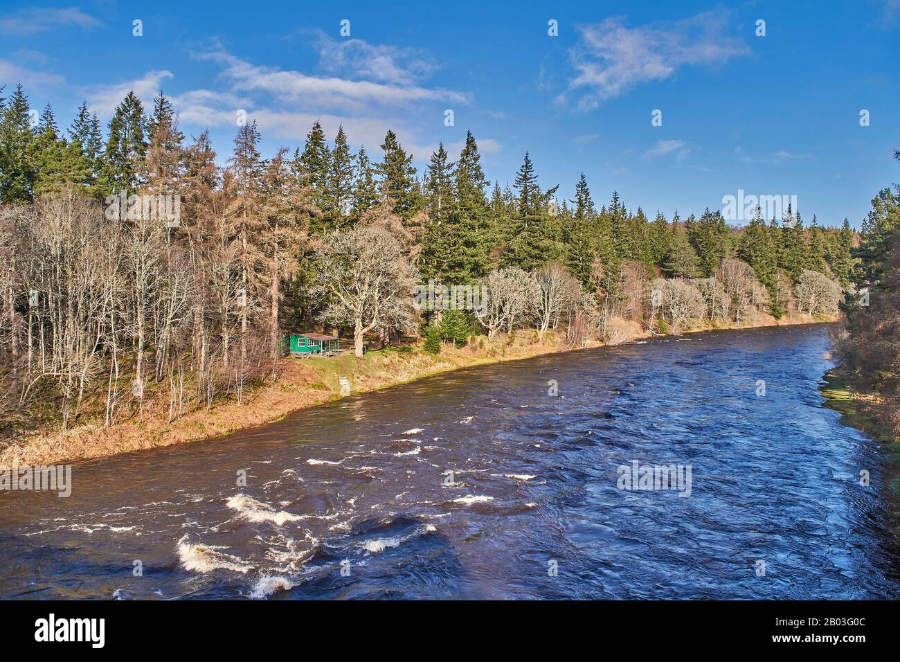 VILLAGE DE CARRON MORAY ECOSSE VUE SUR LA CABANE DE PÊCHE VERTE ET LA RIVIÈRE DEPUIS LA ROUTE UNIQUE DE CARRON ET LE VIEUX PONT FERROVIAIRE QUI TRAVERSE LA RIVIÈRE SPEY Banque D'Images