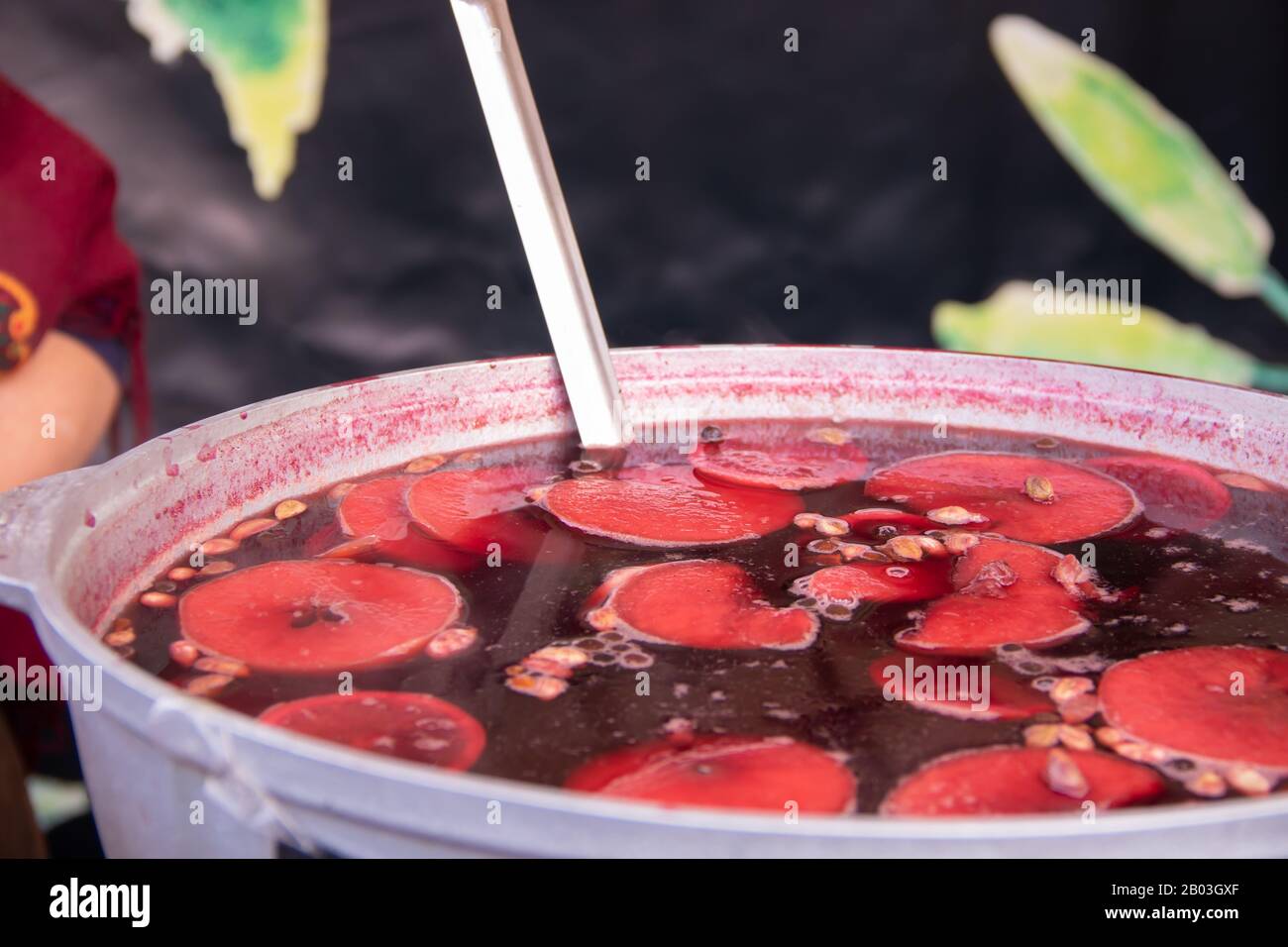 Grande casserole avec vin chaud haché oranges et épices nourriture de rue fastical orange fraise vin chaud dans une grande casserole au festival de s Banque D'Images