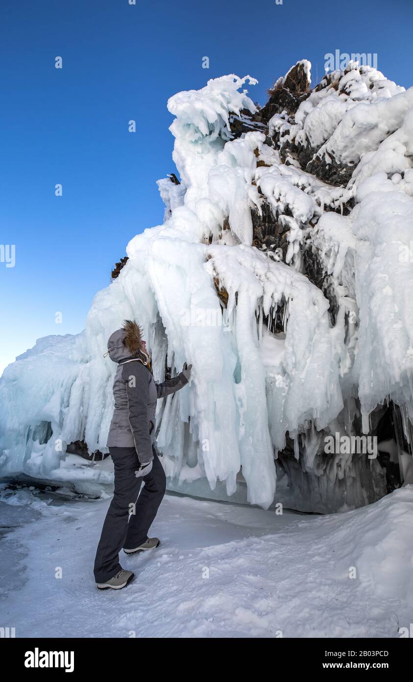 Une femme s'émerveillant devant le mur massif de glace formé par les vagues et le vent. Lac Baikal, Sibérie, Russie. Banque D'Images