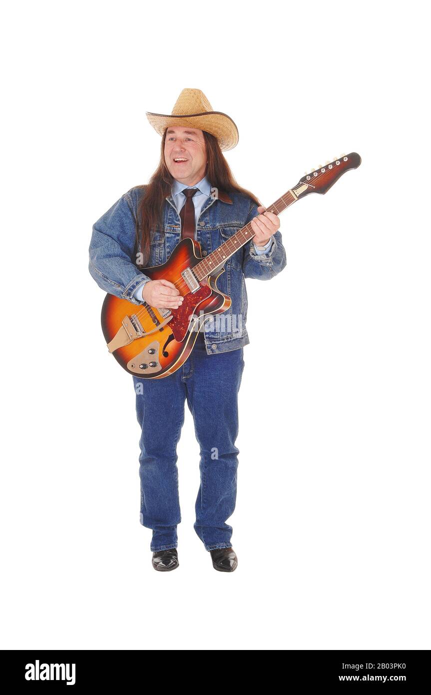 Un bel homme autochtone dans une veste, pantalon jeans et un chapeau de cowboy et permanent à jouer de la guitare, isolée pour fond blanc Banque D'Images