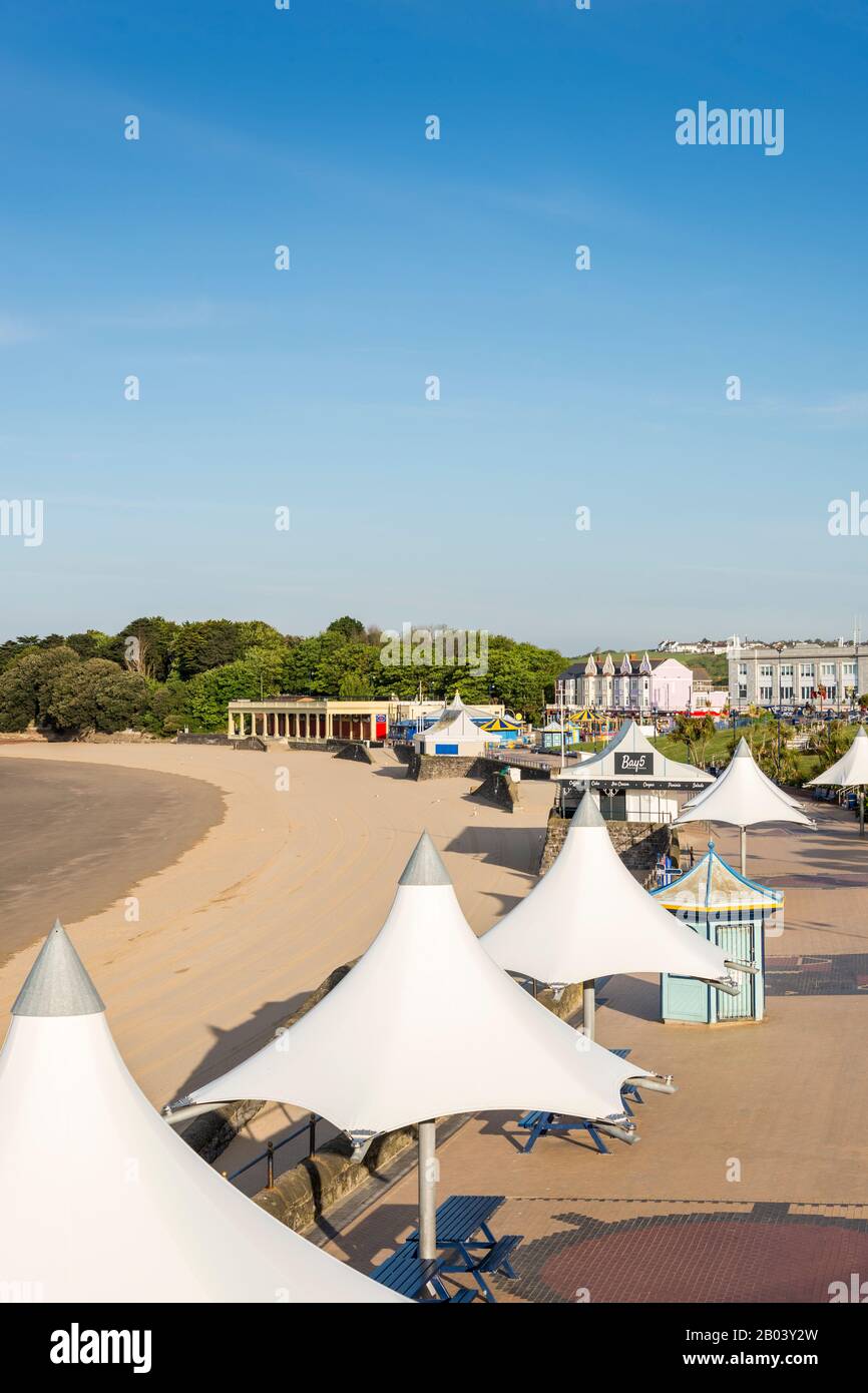 Il est tôt dans une matinée ensoleillée d'été avec un ciel bleu clair. La promenade et la plage de Barry Island sont désertes. Banque D'Images