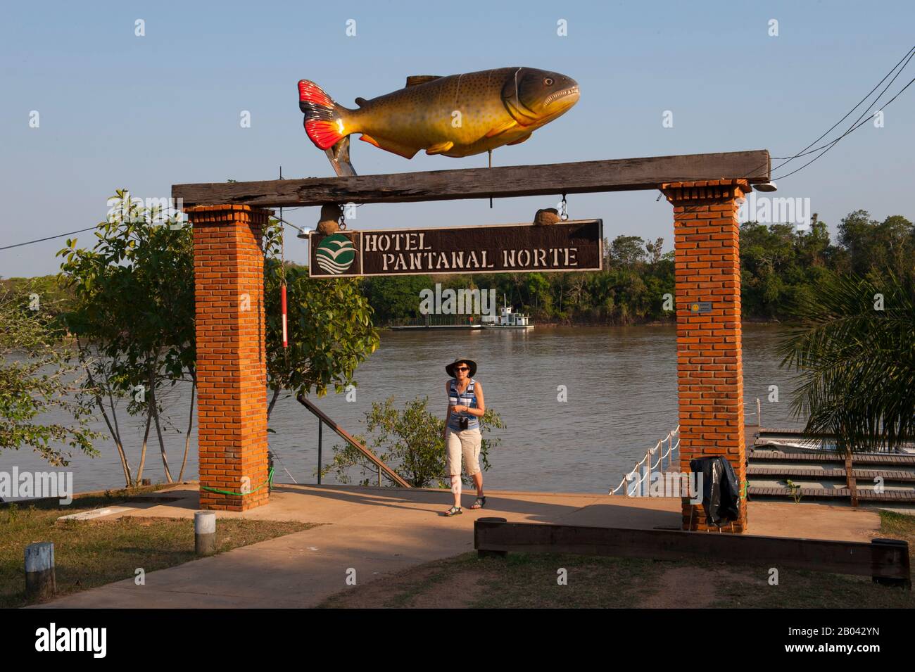 Tourisme (MODÈLE PUBLIÉ 20020923-10) marchant à travers la porte de la jetée de l'Hôtel Pantanal Norte à la rivière Cuiaba à Porto Jofre dans le nord Banque D'Images