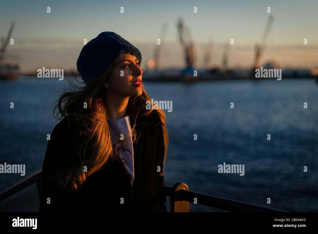 Jeune fille du Moyen-Orient modèle during un coucher de soleil dans le port de Hambourg. Banque D'Images