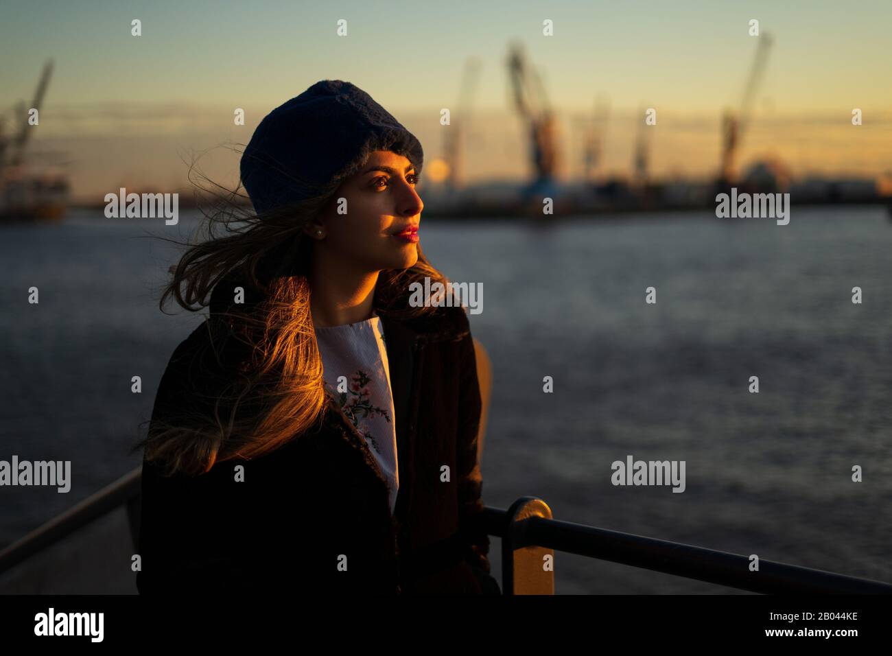 Jeune fille du Moyen-Orient modèle during un coucher de soleil dans le port de Hambourg. Banque D'Images