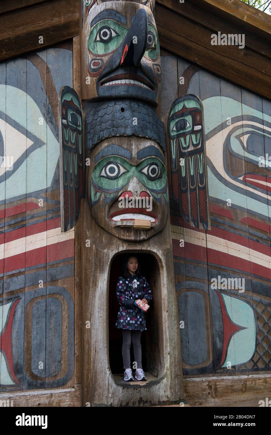 Fille debout à l'entrée de la maison du clan au Totem Bight State Historical Park à Ketchikan, dans le sud-est de l'Alaska, aux États-Unis. Banque D'Images
