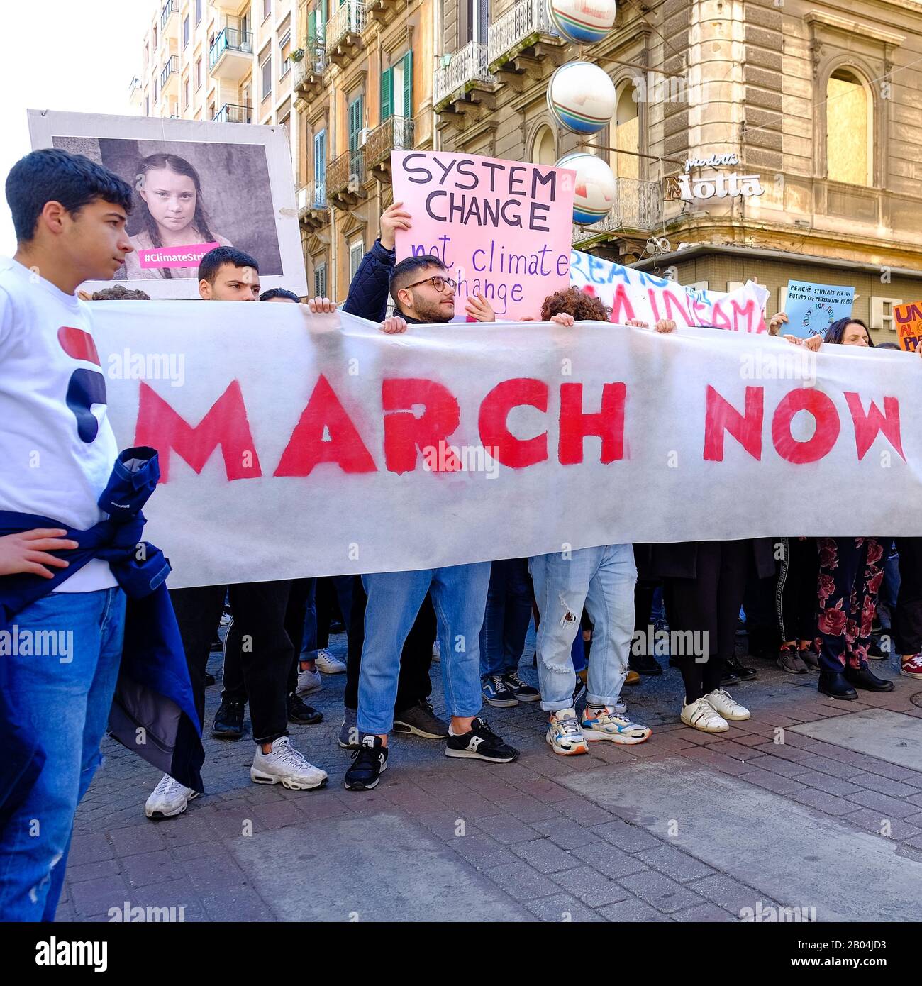 Une procession composée de nombreux jeunes étudiants protestant contre le changement climatique en affichant des pancartes et des bannières avec des messages. Banque D'Images