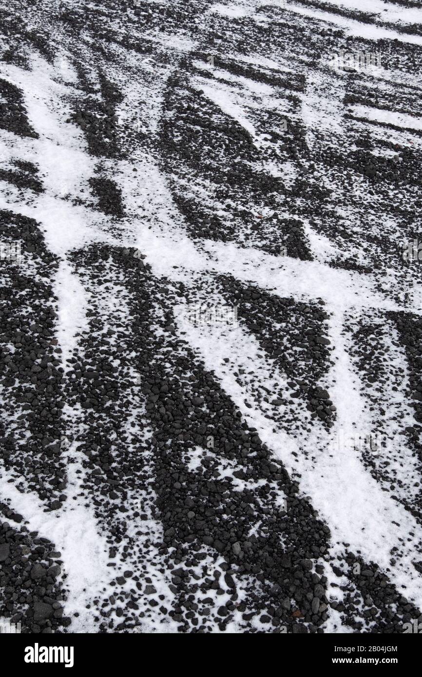 Traces de pneus sur route de basalte enneigée en Islande Banque D'Images