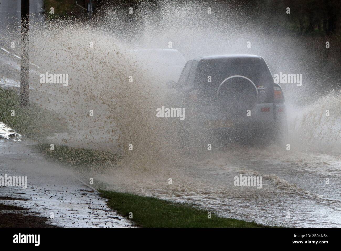 un véhicule 4 x 4 conduit à vitesse par l'eau d'inondation, provoquant une grande quantité de déplacement et de pulvérisation d'eau Banque D'Images