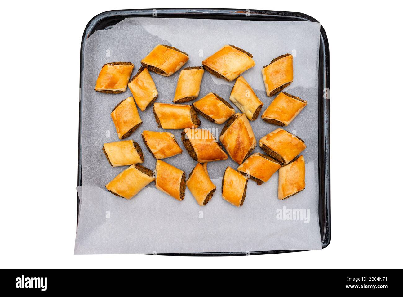 Pâte cuite sur un plateau de papier de cuisson, isolée sur un fond blanc avec un chemin de découpe. Banque D'Images