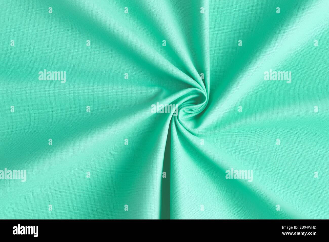 Vue sur le dessus sur le tissu à la menthe aqua tordue. Arrière-plan moderne et abstrait de texture de tissu Banque D'Images