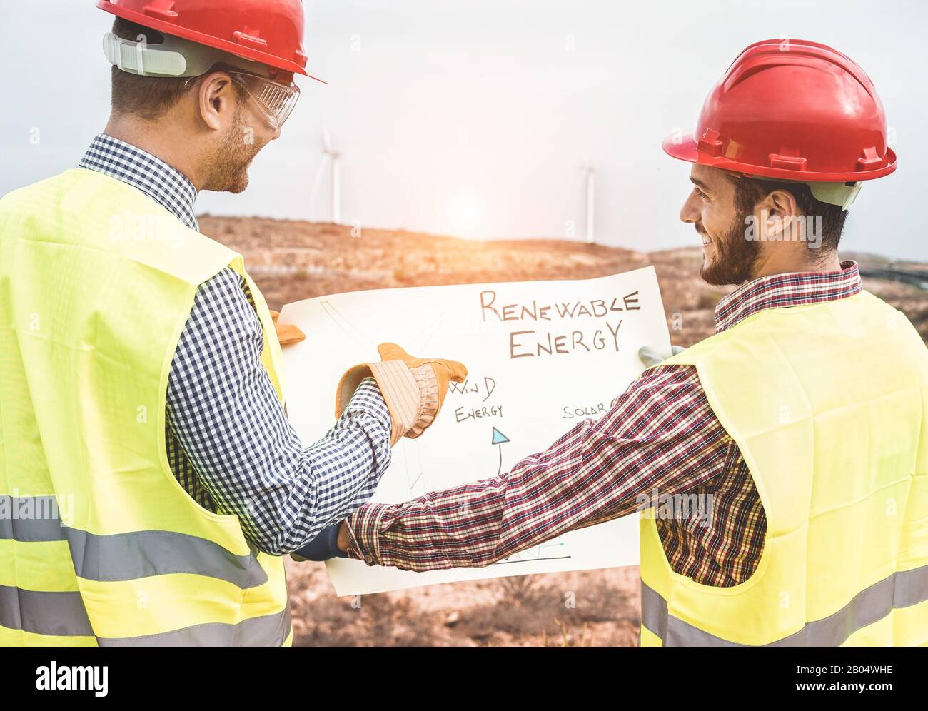 Les ingénieurs ouvriers discutent du projet d'énergie renouvelable - les constructeurs planifient comment construire un nouveau parc éolien - respectueux De L'Environnement, la construction et sa Banque D'Images