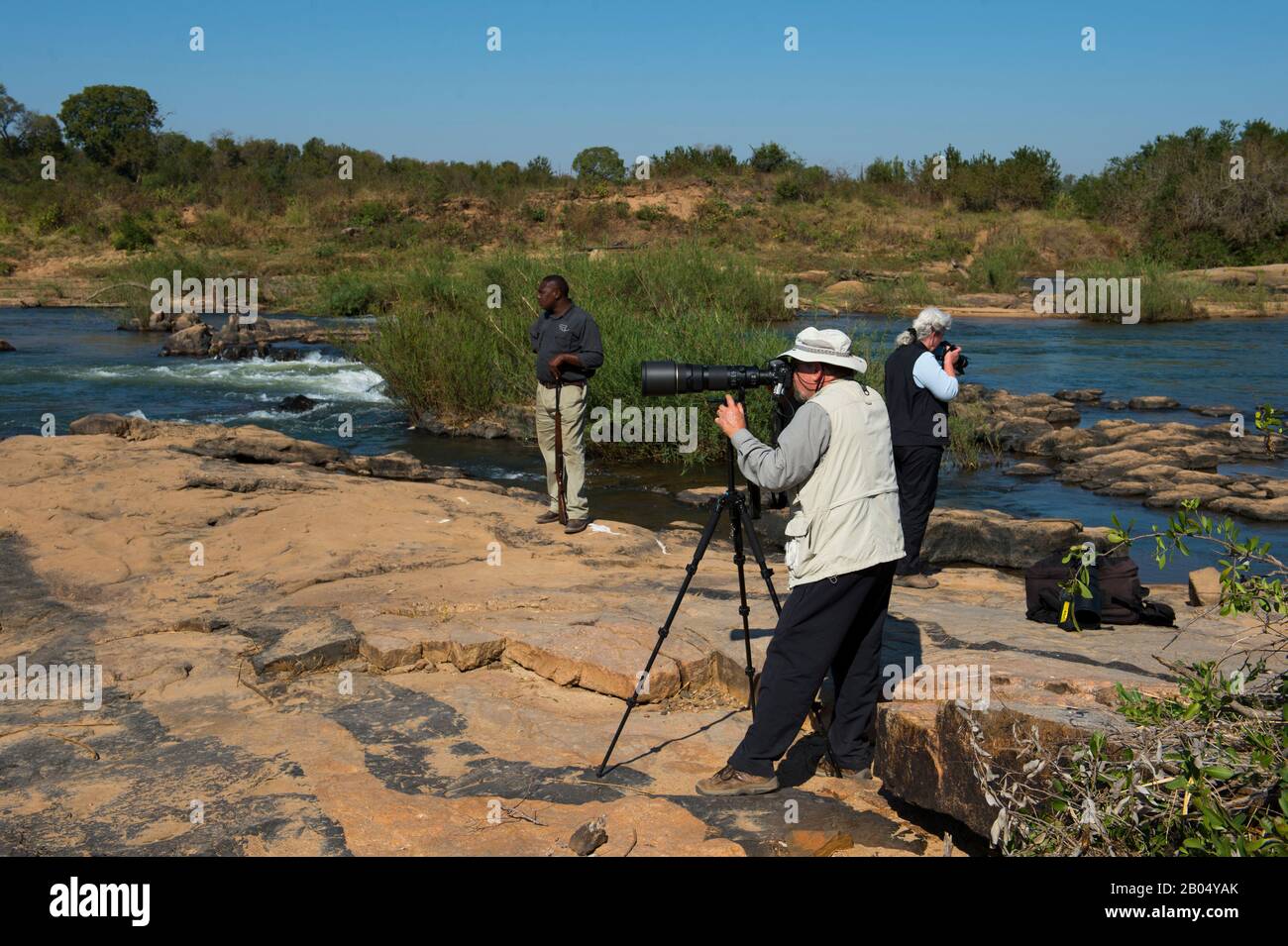 Les touristes photographiant sur la rive fluviale de la rivière Sabie dans la Réserve de jeux de Sali Sands adjacente au parc national Kruger en Afrique du Sud. Banque D'Images