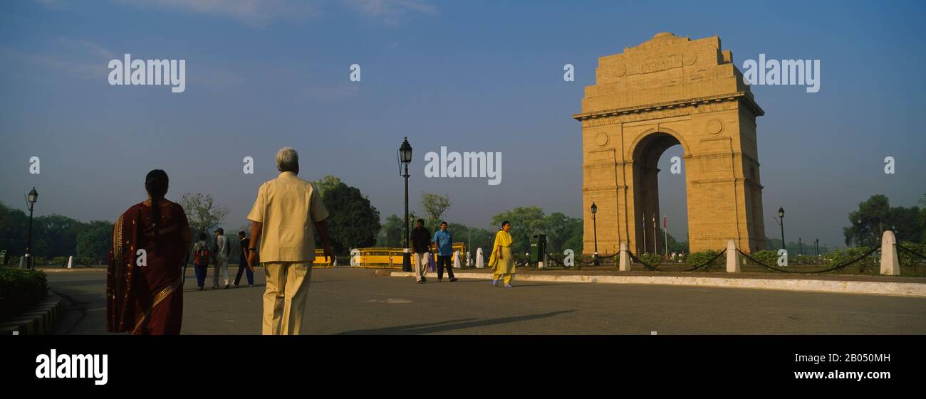 Groupe de touristes marchant devant un monument, porte de l'Inde, New Delhi, Inde Banque D'Images