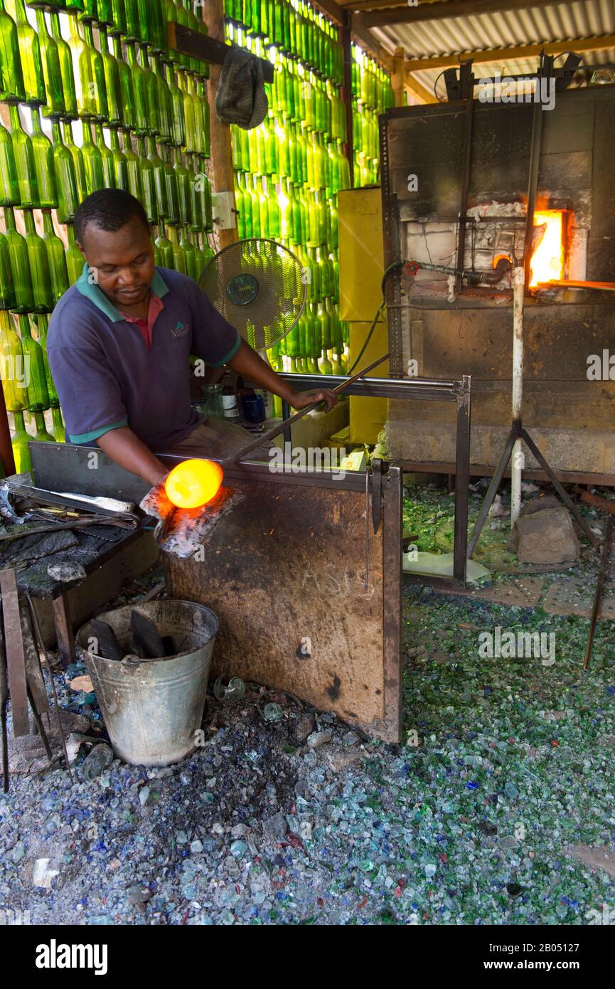 Homme local handicapé (surdité) soufflant du verre à l'aide de matériaux recyclés pour le marché de gros et de détail de la maison de Shanga à Arusha, Tanza Banque D'Images