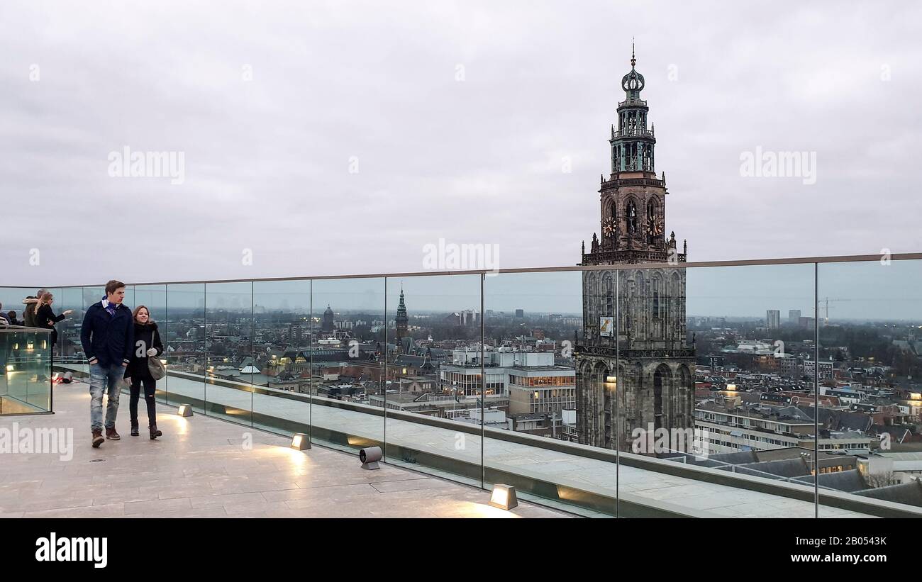 Groningue, Pays-Bas - 6 février 2020: Les gens qui profitent de la vue aérienne sur le toit sur le quartier du centre-ville et la tour gothique de l'église Martini. Banque D'Images