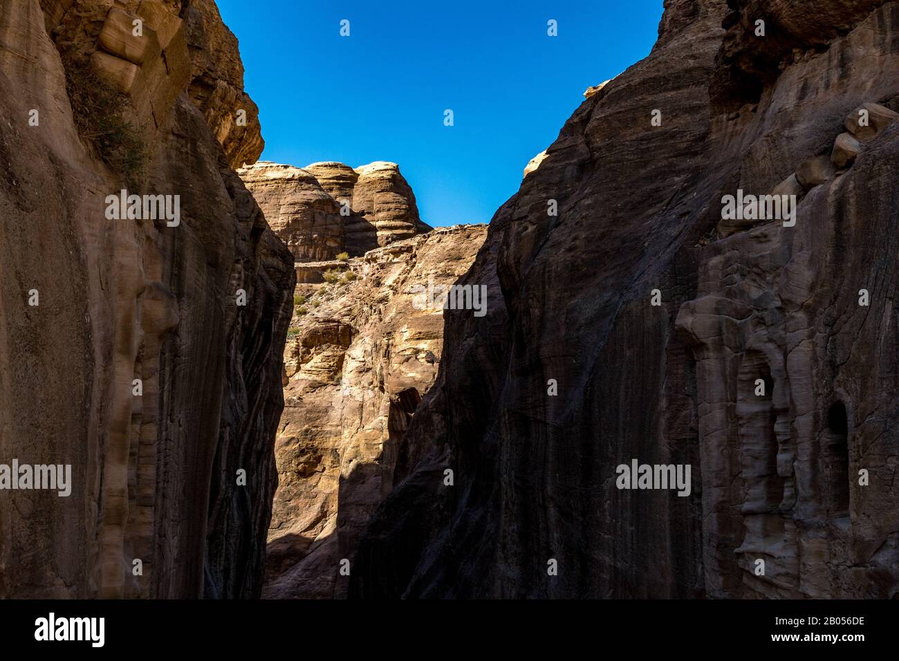 Gorge naturelle à couper le souffle appelée Al-Siq, sculptée dans les falaises rouges par le flux d'eau, le complexe de la ville antique de Petra et l'attraction touristique, Royaume hachémite de Jordanie. Jour d'hiver ensoleillé, ciel sans nuages Banque D'Images