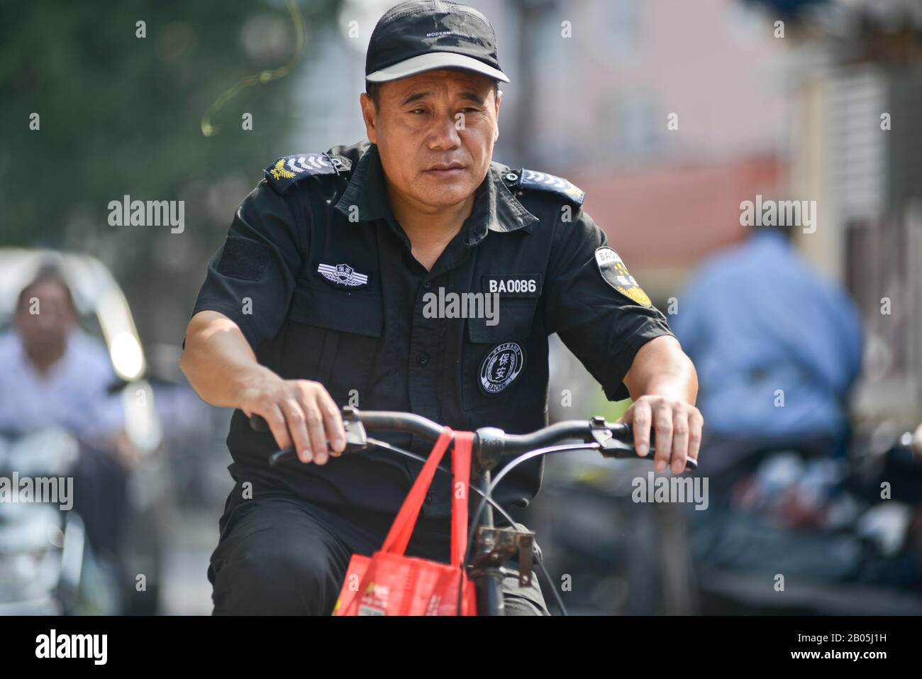 Policier chinois à vélo dans la vieille ville de Shanghai, Penglai Road, Huangpu, Chine Banque D'Images