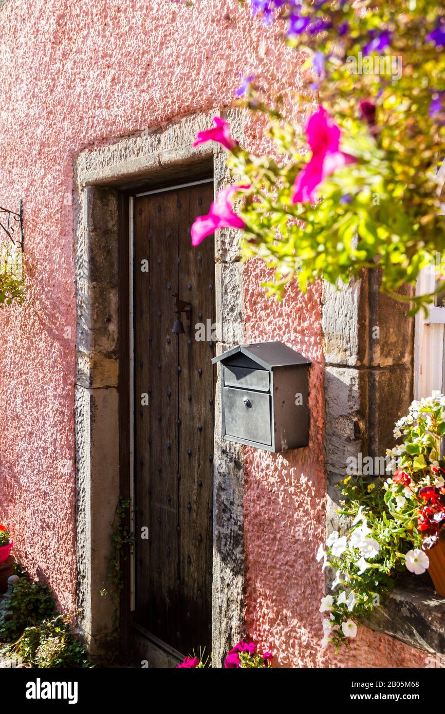 Près d'une belle entrée d'une maison dans un petit village d'Ecosse avec des fleurs suspendues et des couleurs vives Banque D'Images