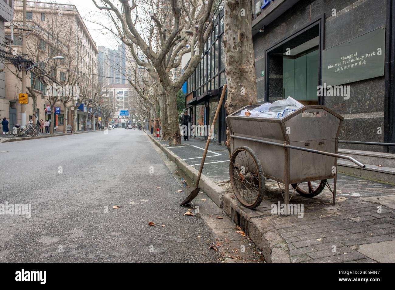Une voiturette de collecte des ordures sur le trottoir d'une rue vide , Shanghai, Chine Banque D'Images