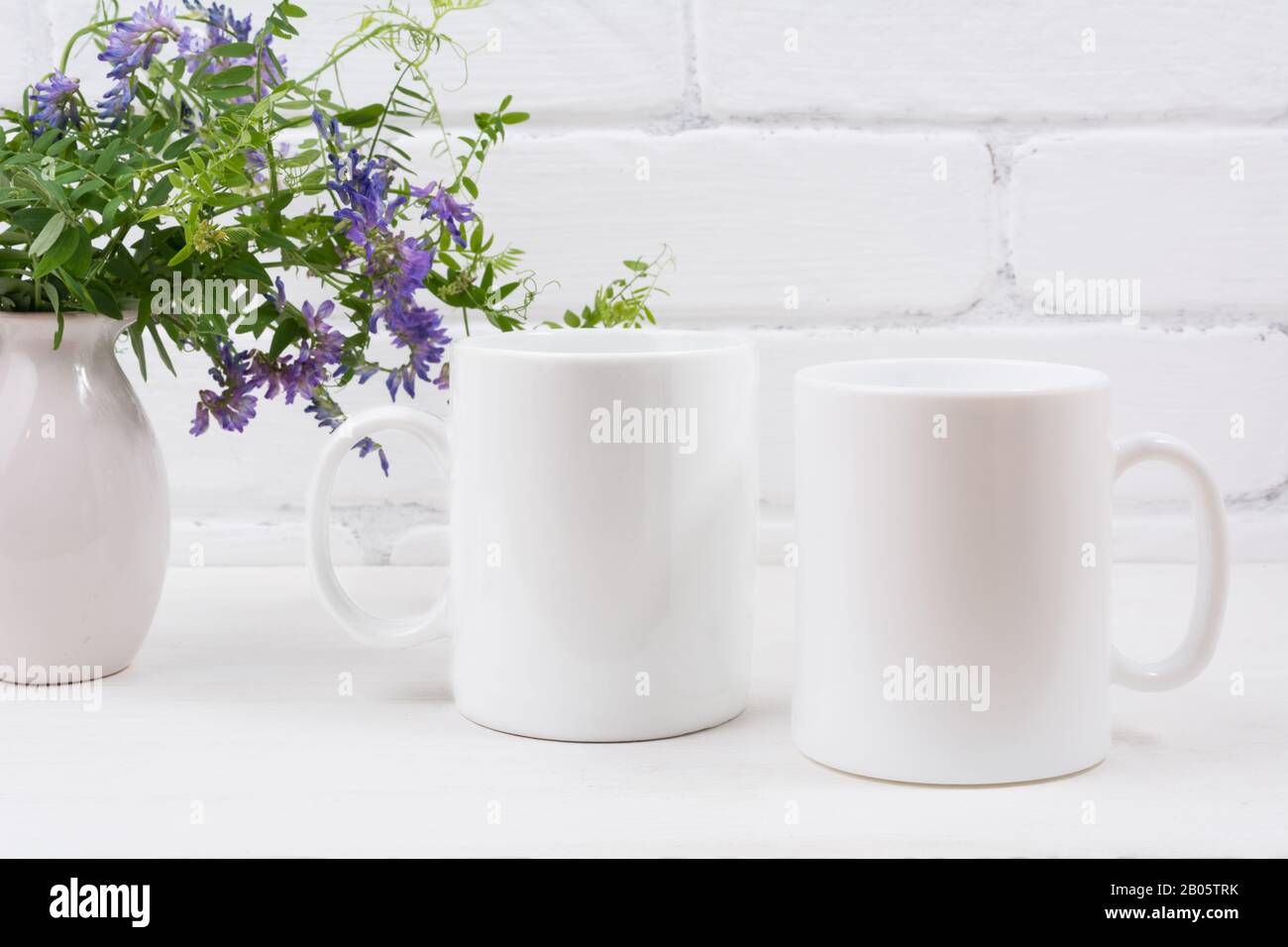 Deux mug à café blanc avec fleurs violettes de pois de souris. Maquette vide pour promotion design. Banque D'Images
