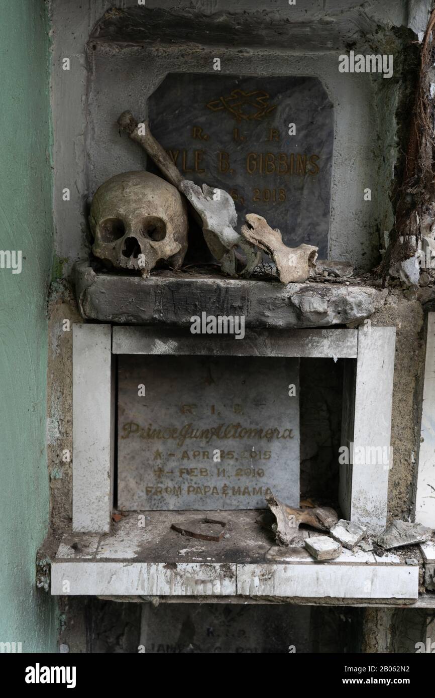 Un crâne humain et des os reposant sur la corniche d'un tombeau dans le cimetière de Calamba, Cebu City, Philippines. Il n'est pas rare de trouver des restes de la défacilité Banque D'Images