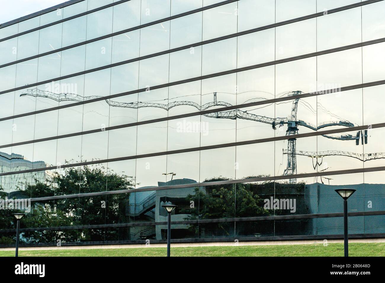 Réflexion de la grue de construction dans le bâtiment de bureau avec Windows Banque D'Images