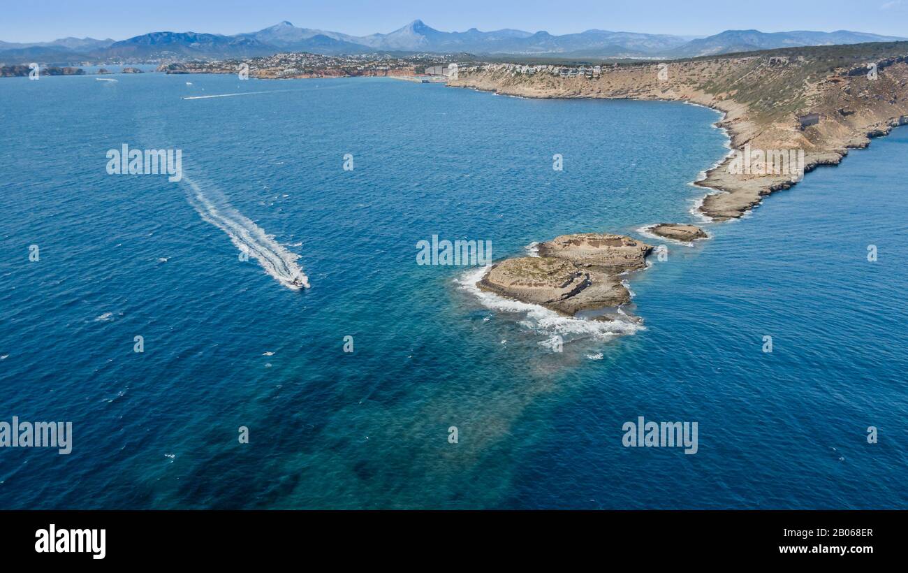 Vue de dessus de la ligne de côte où le bateau blanc tourne dans la mer turquoise Banque D'Images