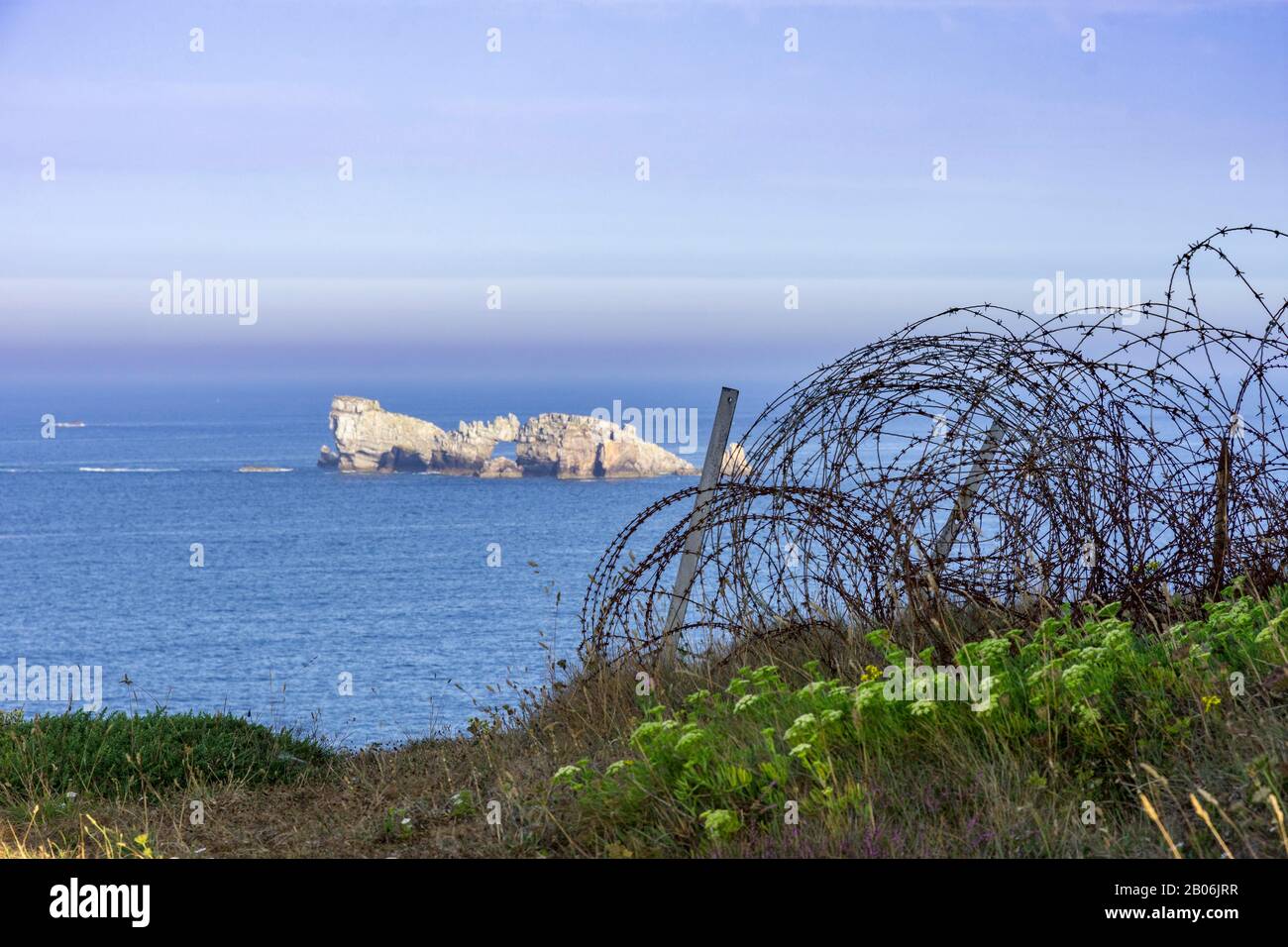 Barbelés et vue sur une petite île dans la mer au Musée commémoratif de bataille de l'Atlantique, Camaret-sur-Mer, Département Finistère, France Banque D'Images