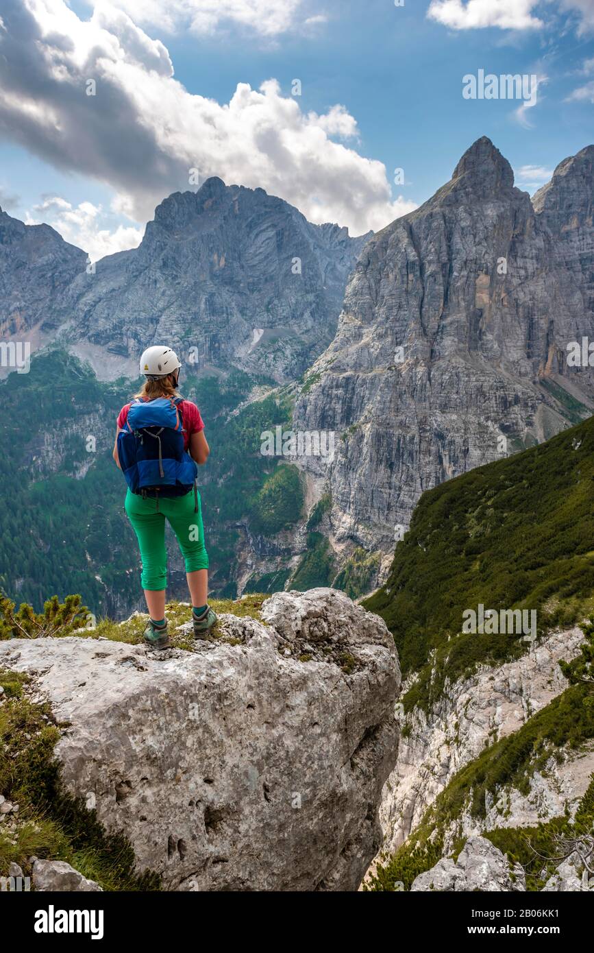 Jeune randonneur avec casque regardant les montagnes, le circuit de Sorapiss, sur la montagne droite Corno Del Doge, Dolomites, Belluno, Italie, Europe Banque D'Images